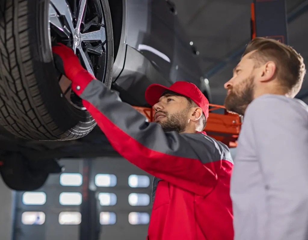 service technician inspects a tire on a car