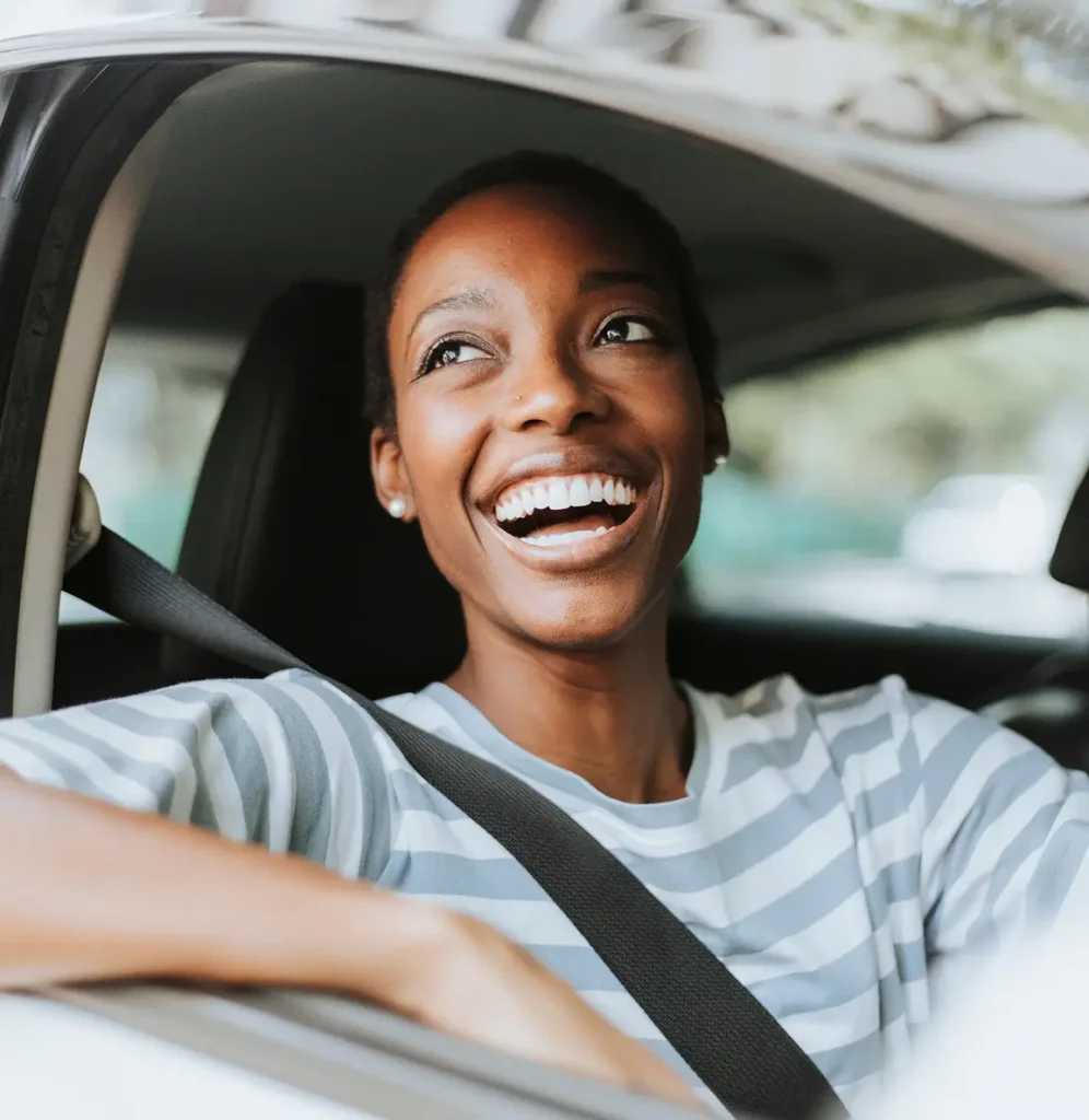 A woman smiles while sitting in a car